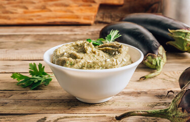 Traditional arabian eggplant dip baba ganoush on rustic wooden table. Selective focus