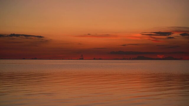 Colorful sunset over calm sea water near tropical beach. Summer vacation concept. Island Koh Phangan, Thailand