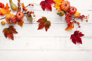 Festive autumn decor from pumpkins, berries and leaves on a white  wooden background. Concept of Thanksgiving day or Halloween. Flat lay autumn composition with copy space.