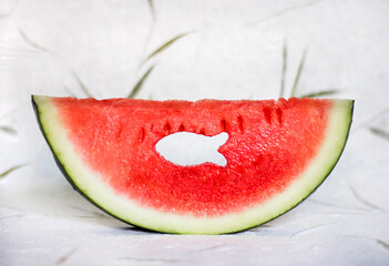 A watermelon slice with fish shape hole in it