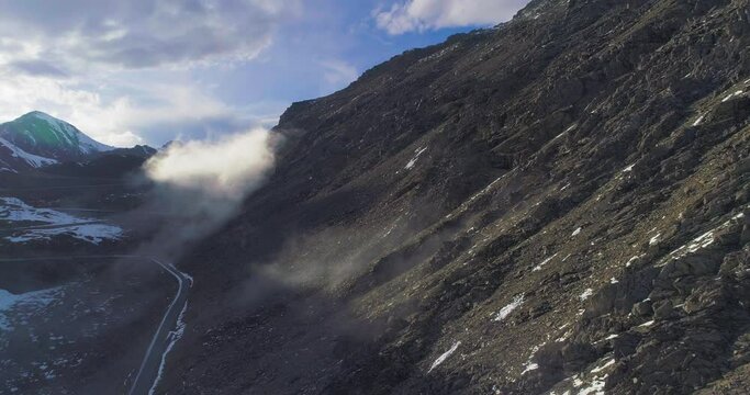 Aerial view of rocky mountain slope with widding road and mist floating in the valley nature scenery at Sichuan China Ba Lang Mount in Xiaojin 