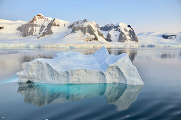 Fototapeta na wymiar Iceberg reflection, blue ice water, calm evening sunset, glacier, Antarctica
