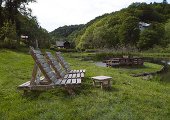 Ecological outdoor recreation, forest, lake, tables, loungers for relaxation, eco tourism background, beautiful natural scene, Cafe terrace in the mountains by the lake surrounded by forest.