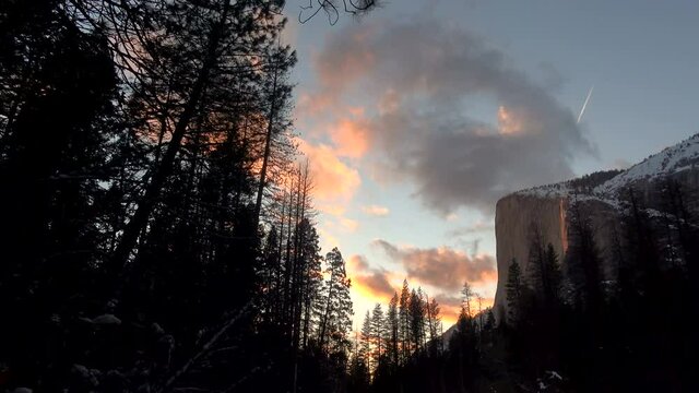 Pan shot of Firefall-- seasonal Horsetail Falls illuminated by evening sunlight in Yosemite National Park, California