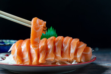 Slice the salmon fillet in a dish with the chopsticks clamped.