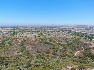 Aerial view of Los Penasquitos Canyon Preserve with Torrey Santa Fe middle neighborhood with residential villas in San Diego County, California, USA.