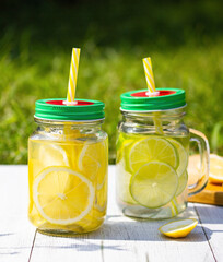 a cocktail of lemon and lime is poured into jars with handles lids and tubes