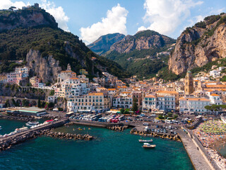 Aerial view from the sea of the Amalfi Coast with Amalfi city, Summer day. Travel and vacation to Europe mountains. Boats and ships, the most popular beach. Breakwater. Houses and hotels. Italy