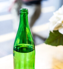 Mineral bottled water for drinking, Green glass bottle with water, alcoholic refreshing drink, selective focus, beautiful blurred bokeh