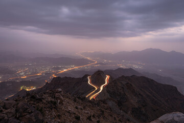 Traffic light trails wrapped around mountain on the zig zag road in Al Hada, Taif region of Saudi...