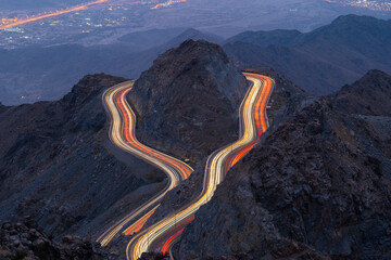 Traffic light trails wrapped around mountain on the zig zag road in Al Hada, Taif region of Saudi...