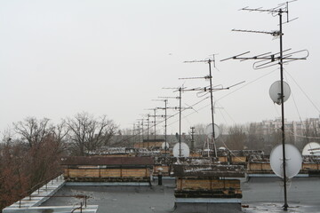 Building roof, old television antennas, satellite dishes, dullness, depression, rusty antennas,...