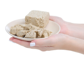 Sunflower halva on plate in hand on white background isolation