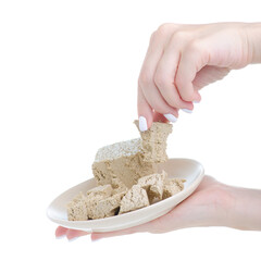 Sunflower halva on plate in hand on white background isolation