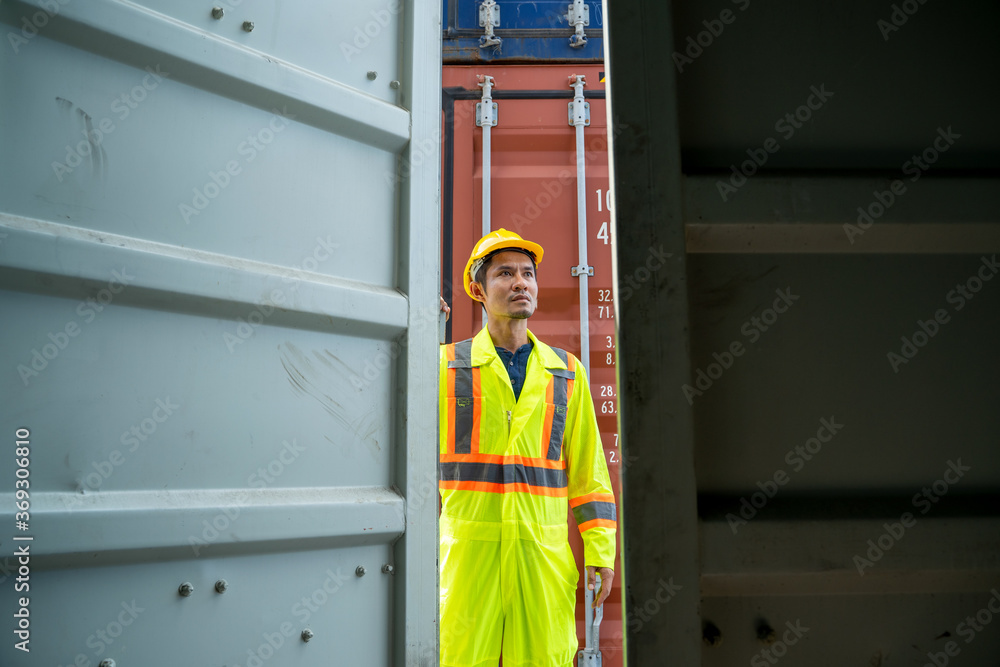 Aufkleber container worker checking container box for logistic export and import in dock.