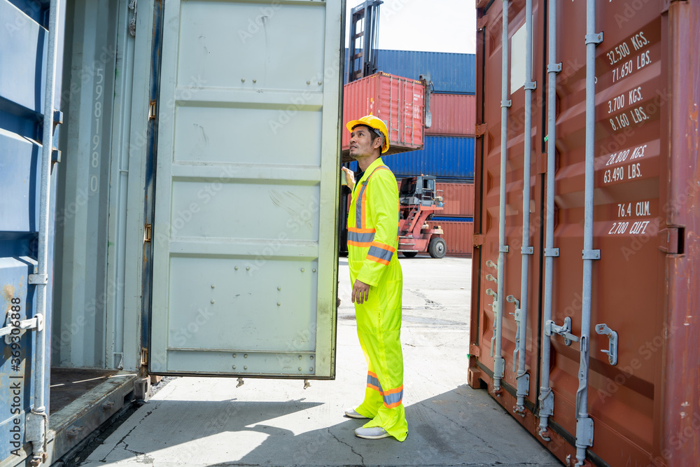 Aufkleber container worker checking container box for logistic export and import in dock.