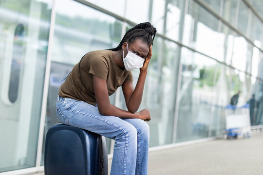 African Woman in medical mask sad and unhappy at the airport terminal with flight canceled