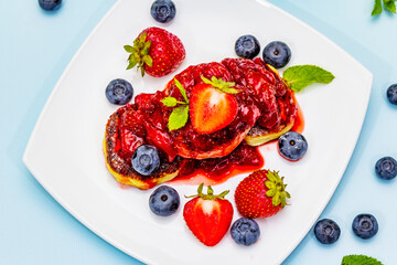 Cottage cheese pancakes with fresh berries and strawberry sauce. Healthy breakfast concept for kids