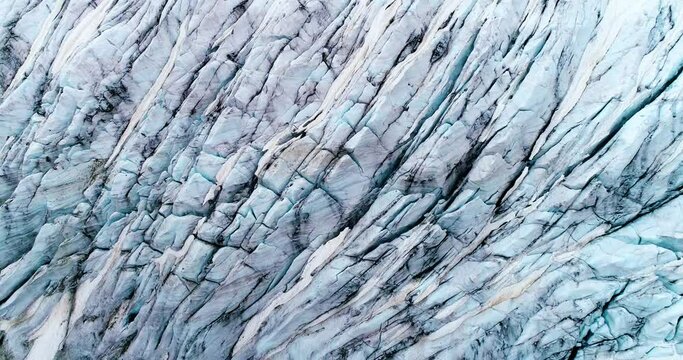 Close-up of a glacier on a mountain, a natural landscape from above. Global warming and climate change concept - aerial view with a drone 4K