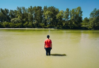 Fototapeta na wymiar Man standing in river in summer