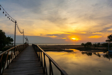 Fototapeta premium Beautiful sunset shot cloudscape over the sea with wooden bridge. (selective focus and white balance shifting applied).