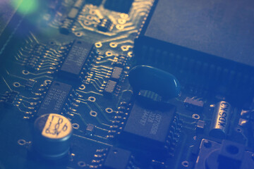 A fragment of a motherboard (PCB) of a computer hardware with many components. Macro photography of...