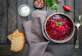 Traditional Ukrainian Russian vegetable beet soup, borscht on wooden background, top view