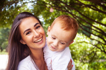 young pretty brunette mother with little cute boy walking in park happy smiling, lifestyle people concept