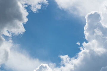 Cumulus clouds around a piece of blue sky