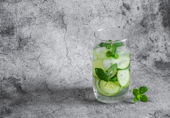 Refreshing cucumber, lime, mint water on a gray background. Summer cold drink, water sassi