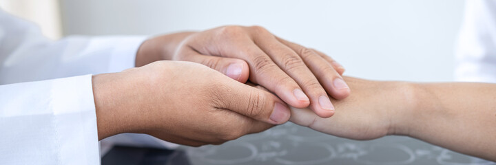 Doctor holding patient's hand to encourage talking with cheering and support