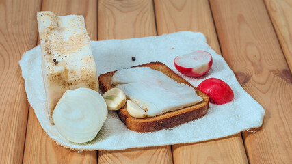 composition with bread, salty bacon , garlic and onion on wooden table.