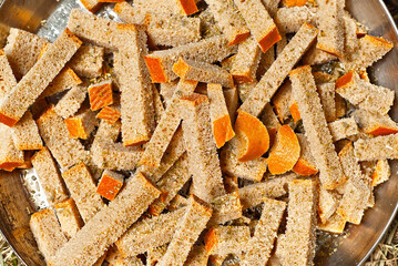 Rusks with oil are cooked on the fire. Many crackers are fried in camping conditions. Texture of dry bread close up.