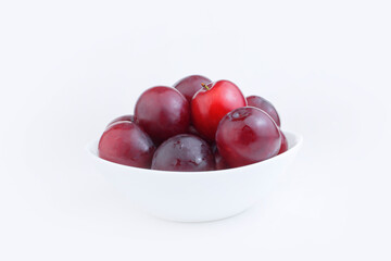 Fresh blue red plums in a white plate on a white background. Harvest plums or recipe for plums. Copy space