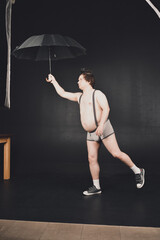 Cheerful guy walks under an umbrella