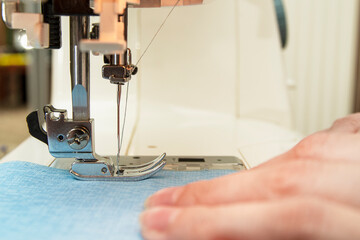 Woman sews on a sewing machine