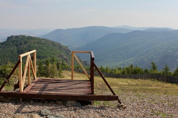 A wooden bench in front of a mountain