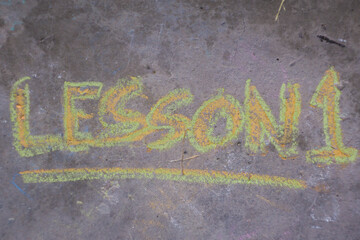 Word "lesson" written on concrete. Education concept