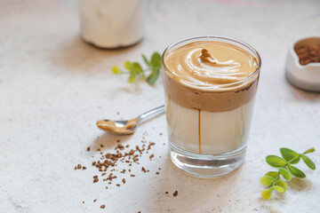 Dalgona Coffee, a cool fluffy whipped coffee in a glass. Latte espresso with coffee foam in tall glass. Trendy drink