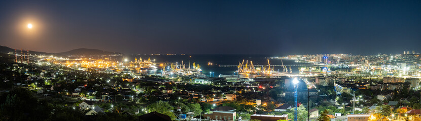 Fototapeta premium Panorama of the city of Novorossiysk. Seaport. Tanker. Cargo port. High modern houses by the sea. A clear sunny day.