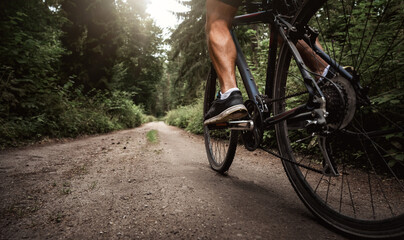 Close up of a biker riding a bike through the forest road