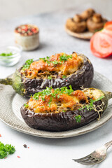 Baked aubergine or eggplant boats stuffed with mushrooms, vegetables and cheese