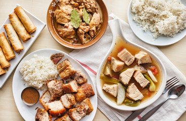 filipino dinner with sinigang, lechon kawali, and chicken adobo top down composition