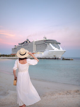 Young woman by the cruise ship at sunset