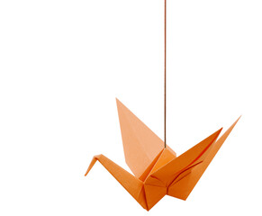 An orange origami paper bird with haning string isolated white