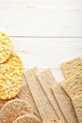 Various types of healthy whole grain crispbreads on white wooden background. Vertical foto