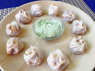 steamed Tibetan momos, the traditional dumplings with different fillings. served with sauce. Close up, side view
