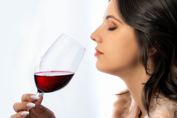 Face shot of wine lover smelling red wine aroma.