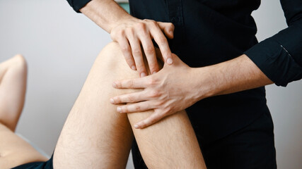 Young man having his knee examined by specialist. Physiotherapy knee flexibility. High quality photo
