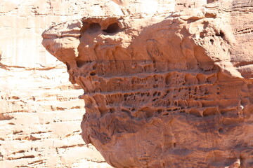 Deserted landscape view of the Wadi Rum desert, close-up of a rock cliff,  mountain and dunes, orange and red, Jordan.